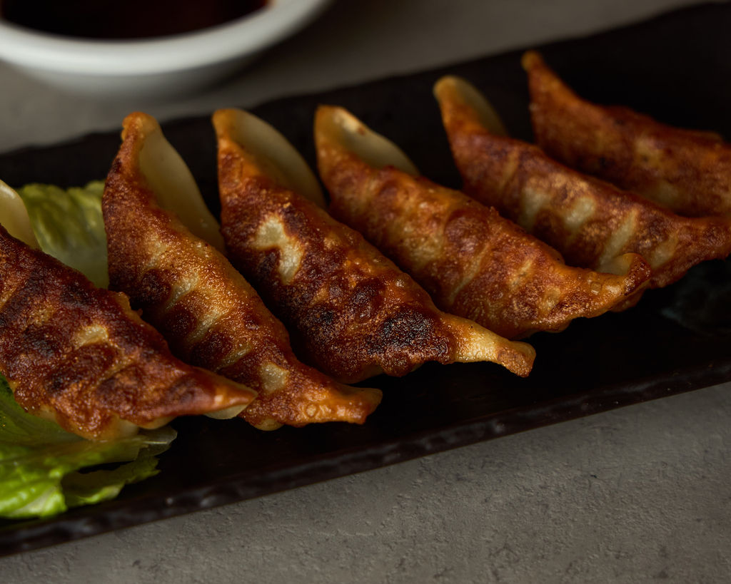 Close-up of crispy pan-fried gyoza showing golden-brown char on the skin